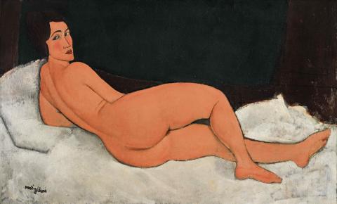 Eine Frau nackt auf dem Rücken auf einem Bett liegend