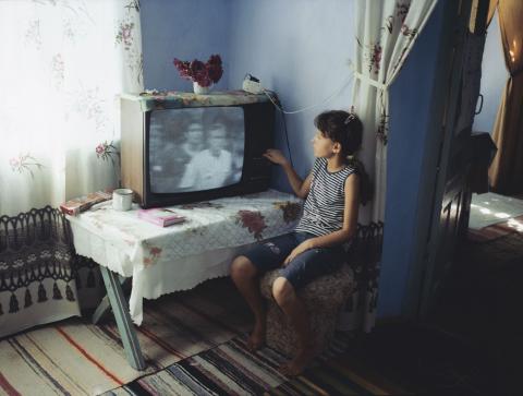 Mädchen sitzt alleine vorm Fernseher
