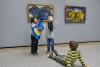 Drei Kinder spielen mit zwei Handpuppen vor Werken von Franz Marc in der Staatsgalerie Stuttgart.